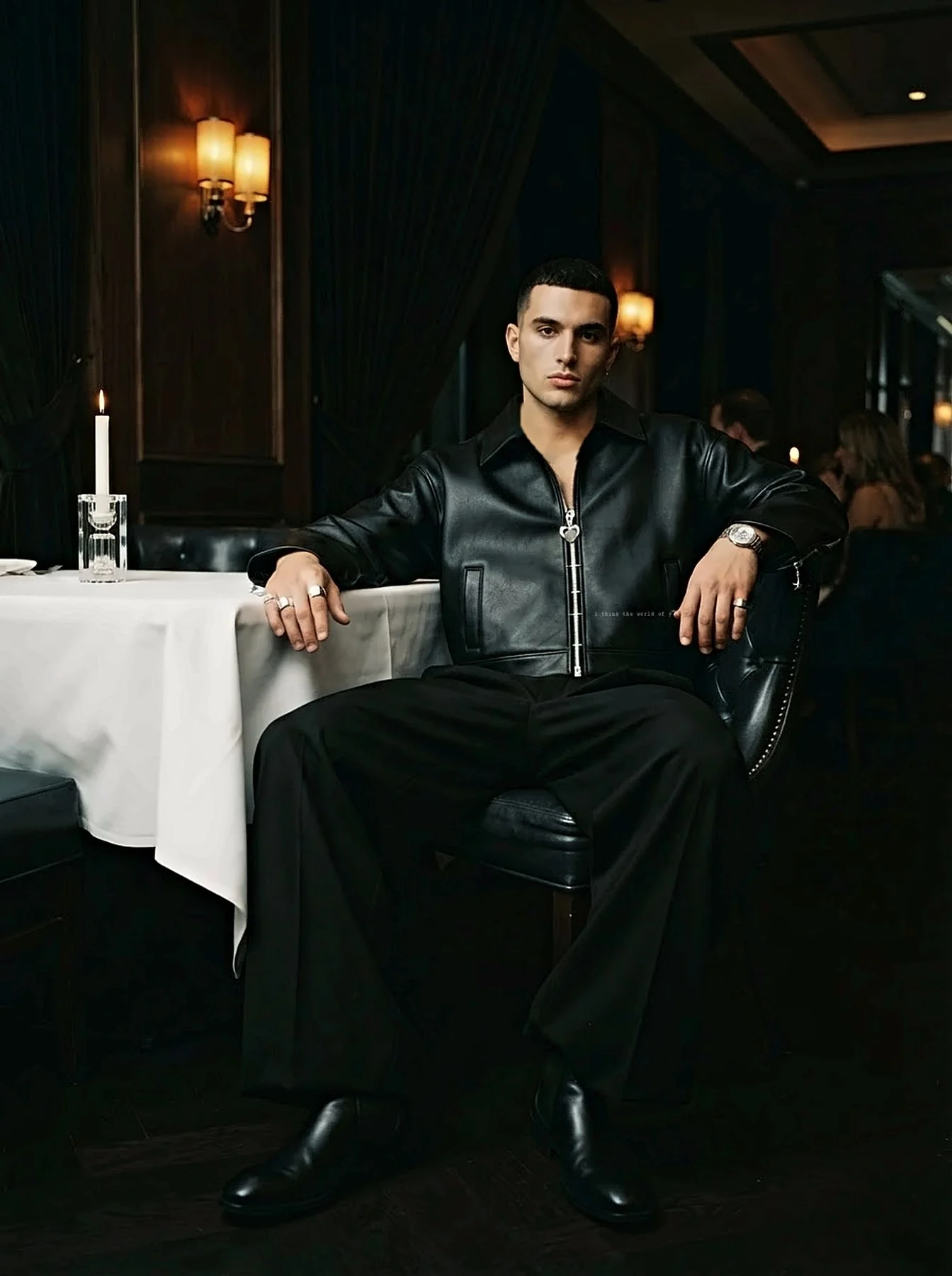 A man seated at a white tablecloth wearing the jacket